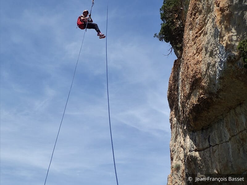 personne pratiquant la descente en rappel au rocher de sion